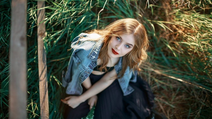 Woman with blue eyes and red lipstick in a jeans jacket
