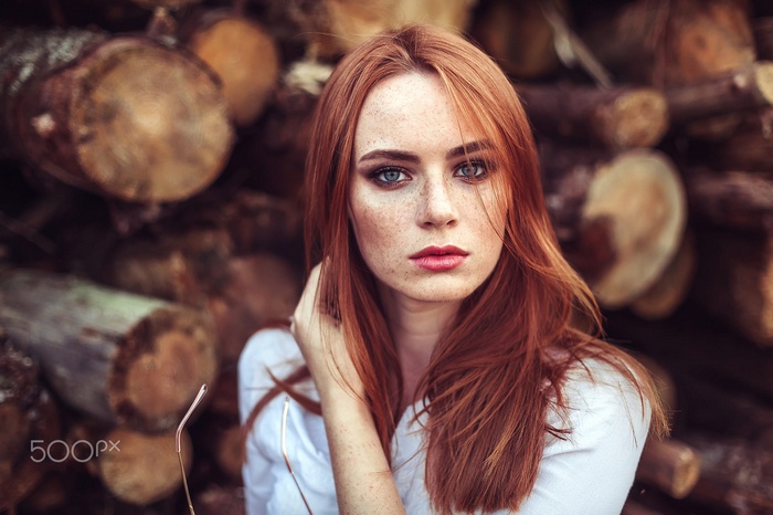 Redhead woman with freckles and blue eyes in white shirt