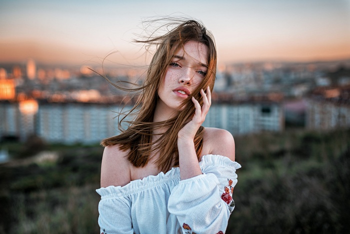 Portrait of a young woman with freckles outdoors
