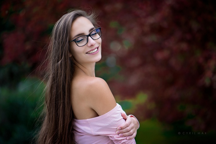 Pavlina with glasses outdoors, smiling with closed eyes