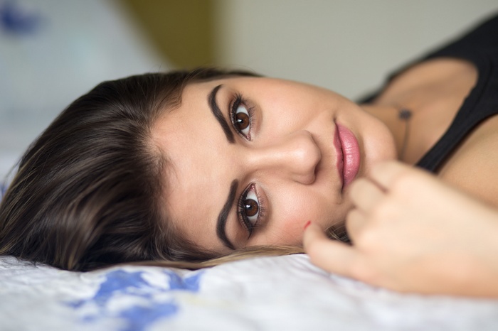 Woman lying on a bed, close-up portrait