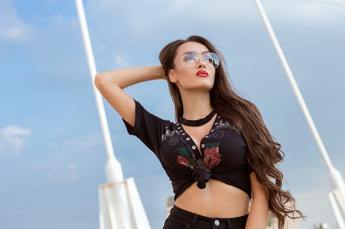 Woman with glasses and red lipstick outdoors