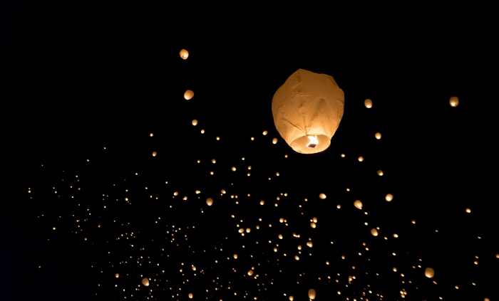Many sky lanterns floating in the night sky