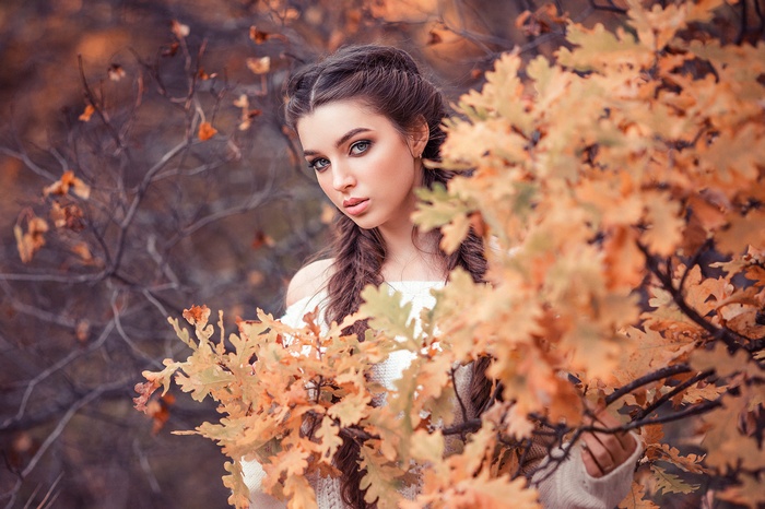 Portrait of a woman with braids in fall foliage