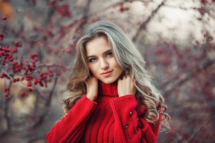 Woman with long hair wearing a red sweater outdoors
