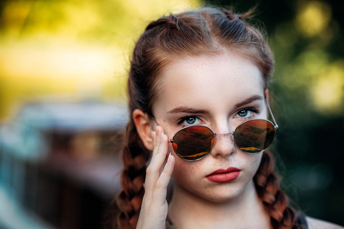 Redhead girl with freckles and sunglasses, portrait