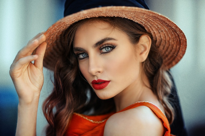 Woman with blue eyes, red lipstick, and hat