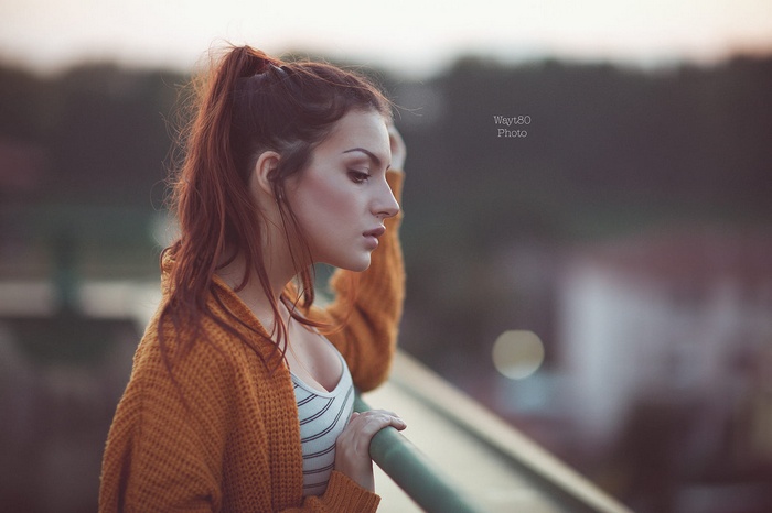 Woman in orange sweater with ponytail