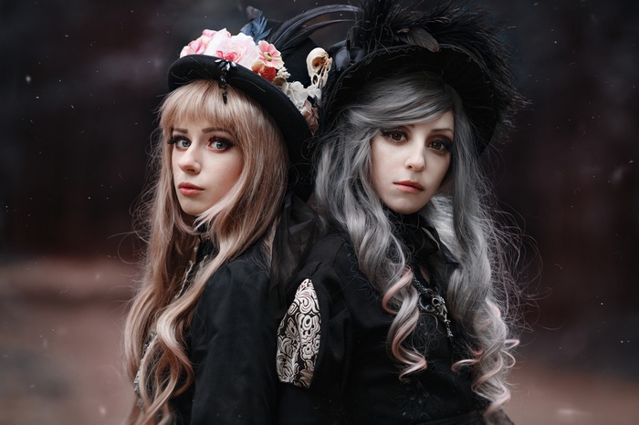 Two women in gothic attire with hats