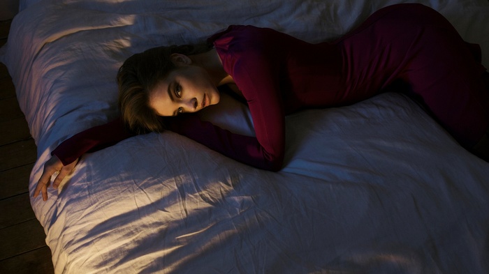 Barbara Palvin in a purple dress lying on a bed