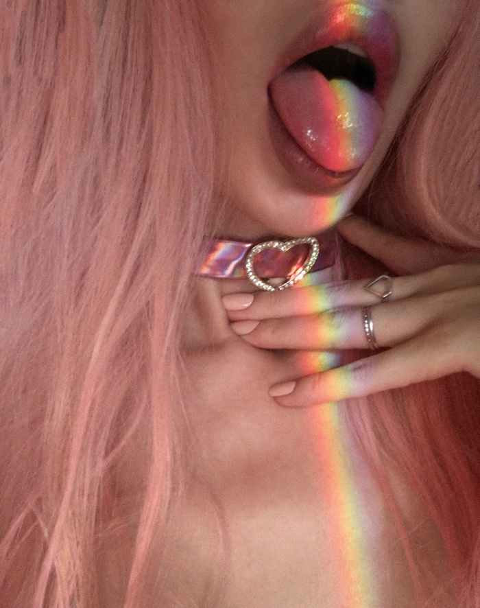 Woman with pink hair and rainbow light