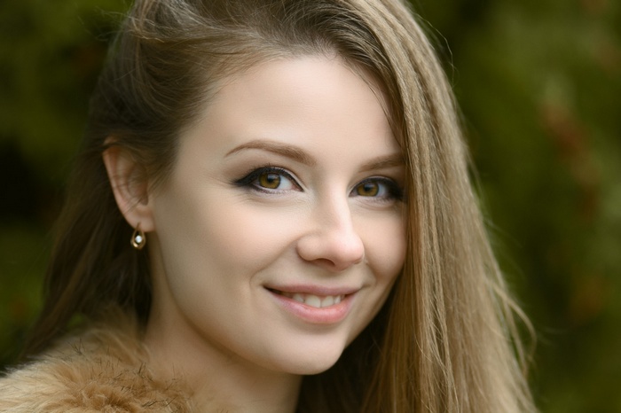 Woman with blonde hair and brown eyes smiling