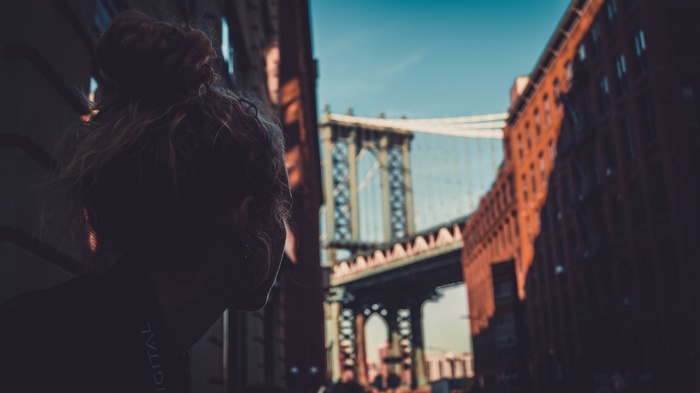Woman looking at Manhattan Bridge in DUMBO, New York City
