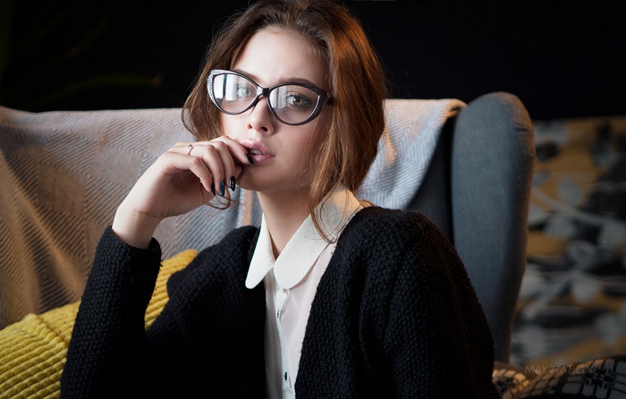 Woman with glasses wearing a black cardigan