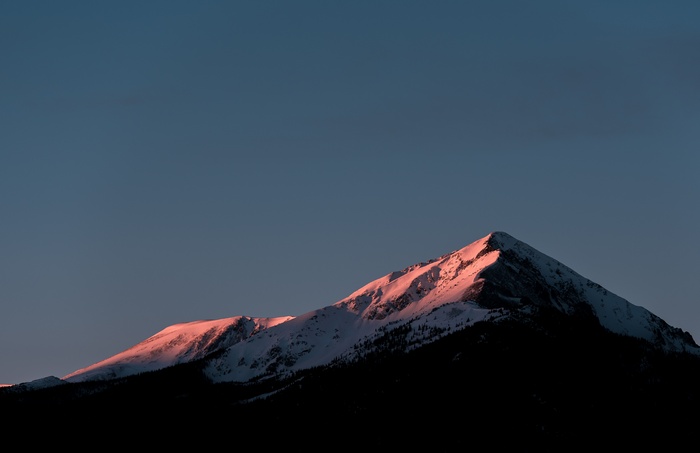Snow-covered mountain peak at sunset