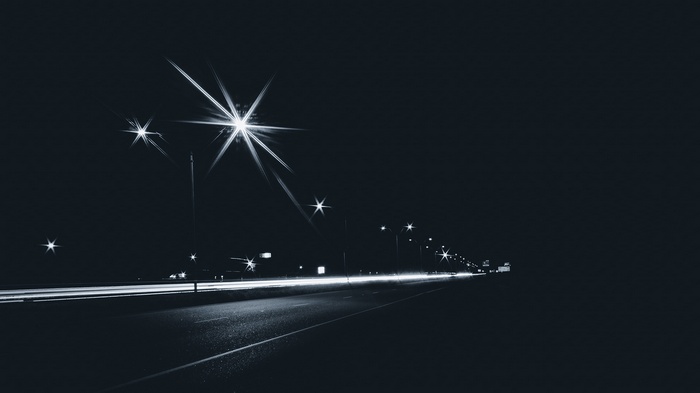 Night highway with light trails and streetlights