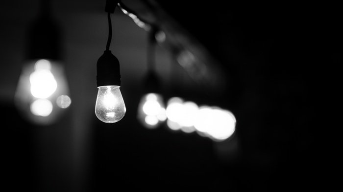 Monochrome string of light bulbs with bokeh