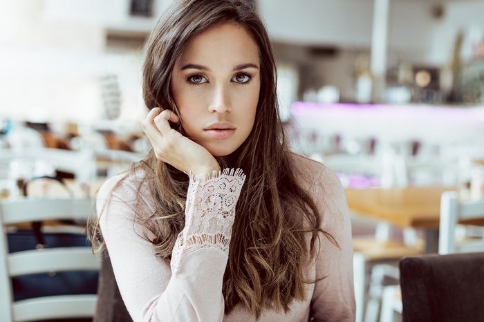 Woman with long brown hair in a cafe