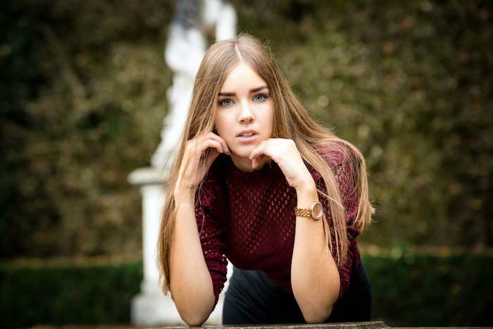 Woman with long blonde hair wearing a maroon sweater