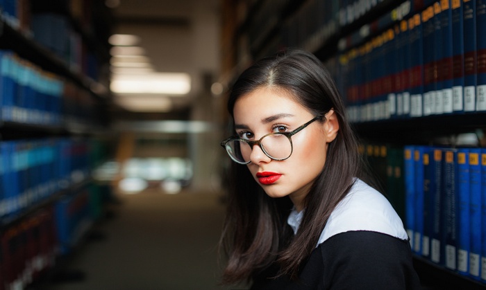 Woman with glasses and red lipstick in library