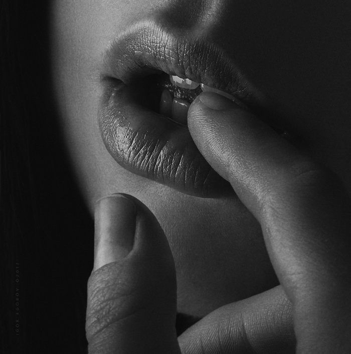 Monochrome close-up of a woman's lips and fingers