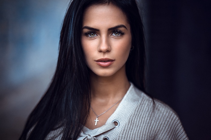 Woman with dark hair and a cross necklace