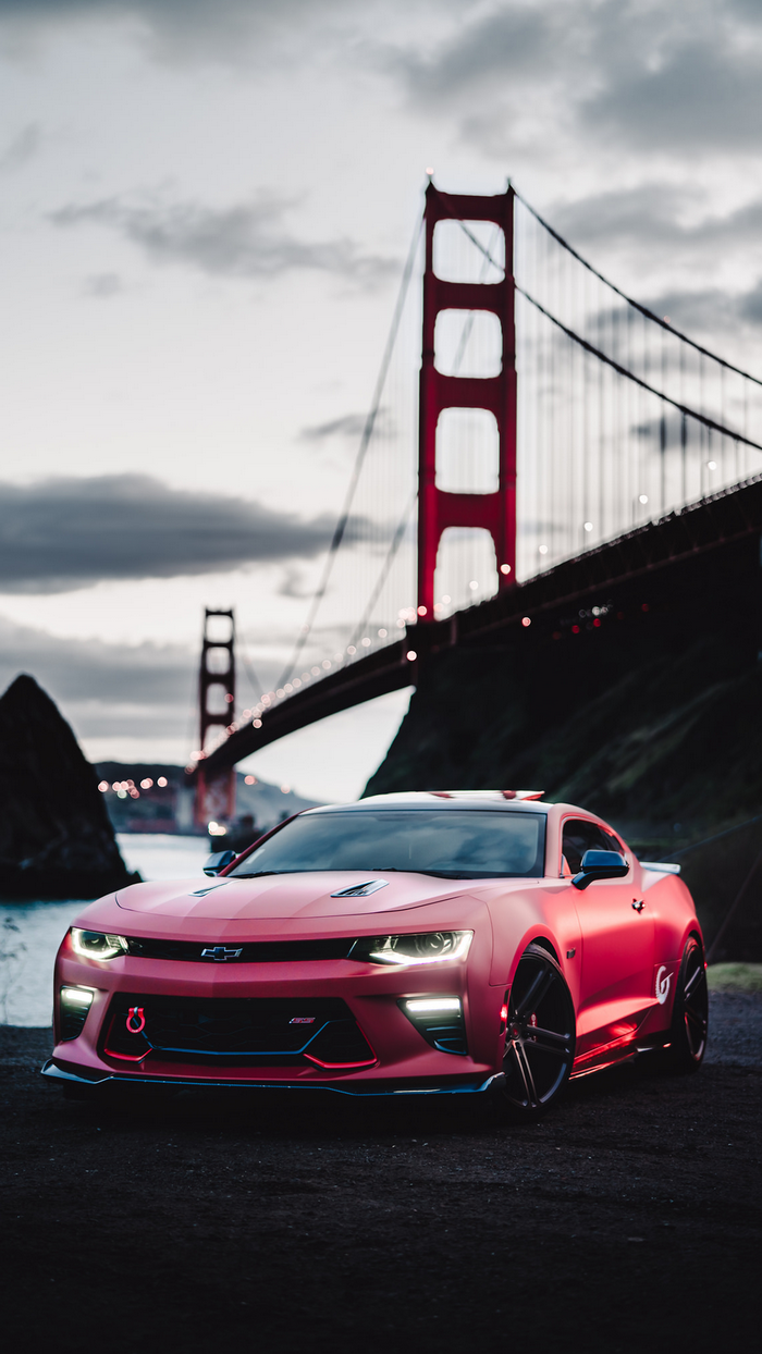 Red Chevrolet Camaro in front of Golden Gate Bridge