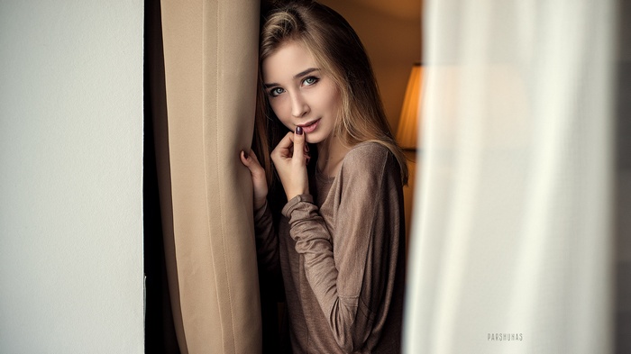 Woman with blonde hair touching her lips