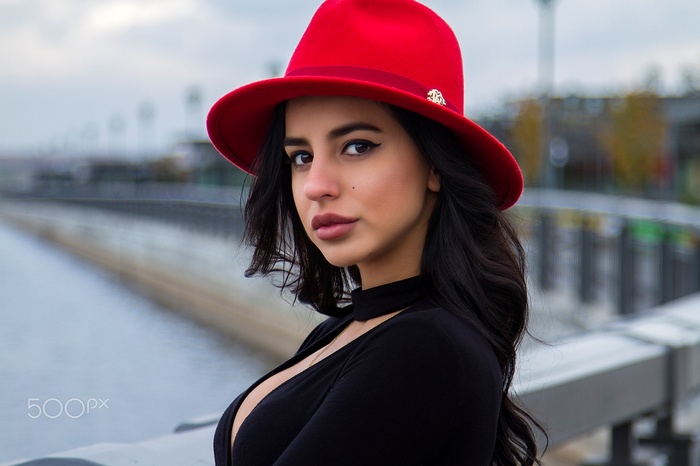 Woman in red hat and black top outdoors
