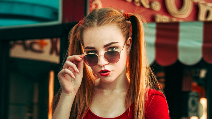 Woman with pigtails wearing sunglasses and red lipstick