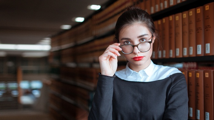 Woman with glasses and red lipstick in library