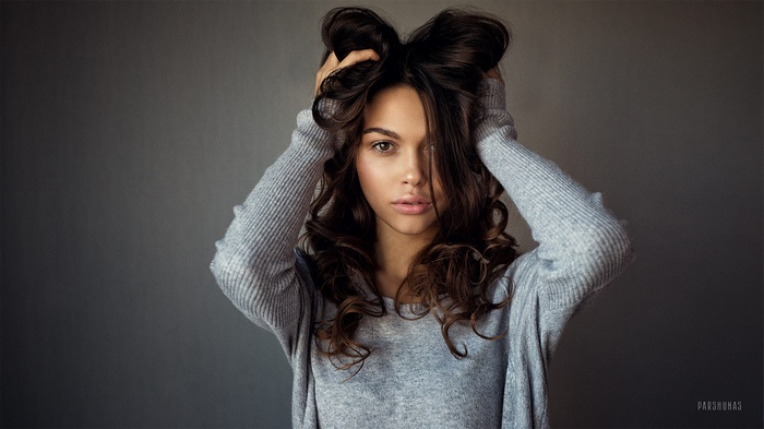 Woman with hands in her long brown hair