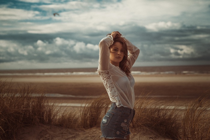 brunette, hands in hair, standing, beach, short shorts, see-through clothing, jean shorts, portrait, face, white shirt, Marcel J. Zahlten, high waisted, women, women outdoors, sky