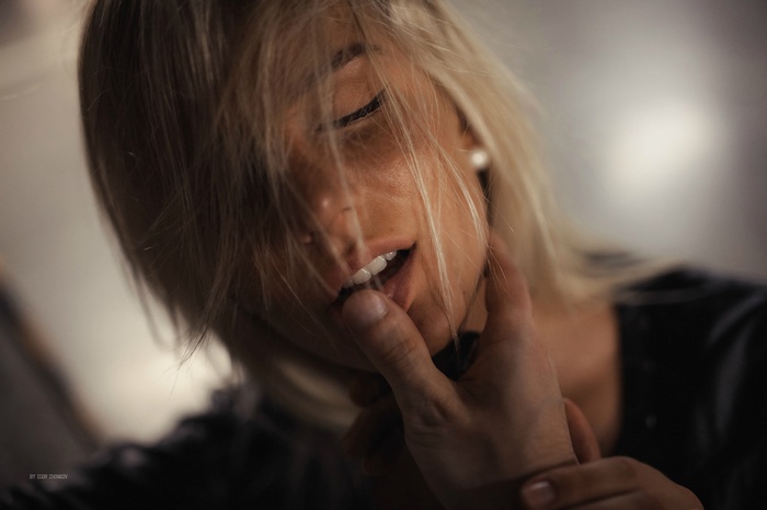 Woman with blonde hair and finger on lips