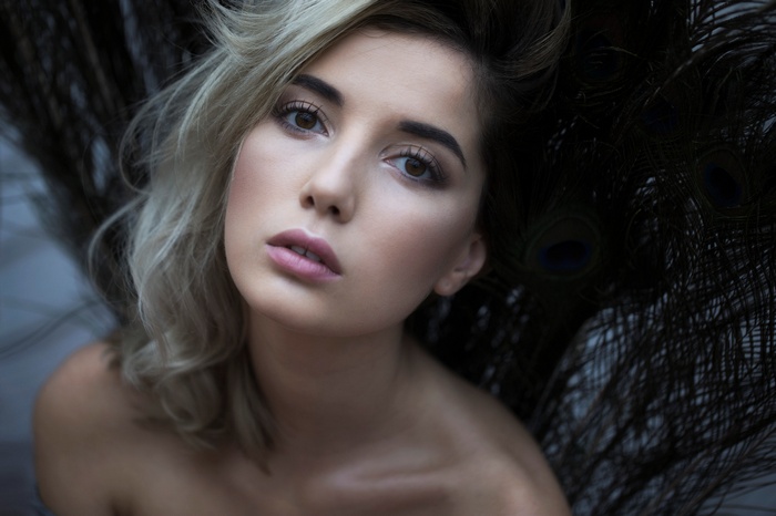 Woman with blonde hair and peacock feathers
