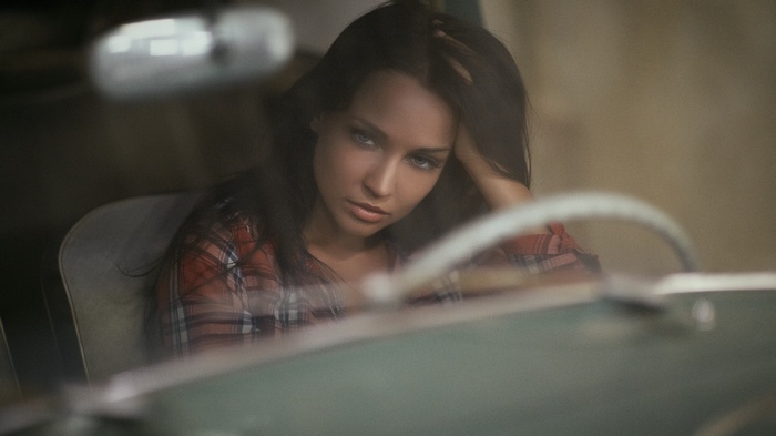 Angelina Petrova in a car interior wearing a plaid shirt