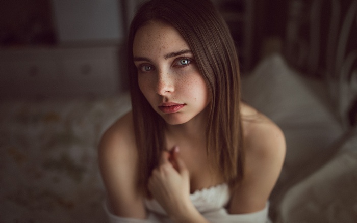 Woman with blue eyes and freckles looking at the camera