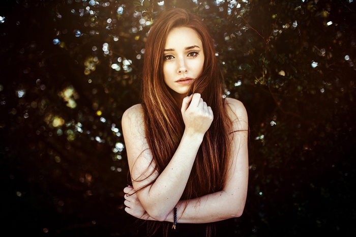 Woman with long brown hair in a forest