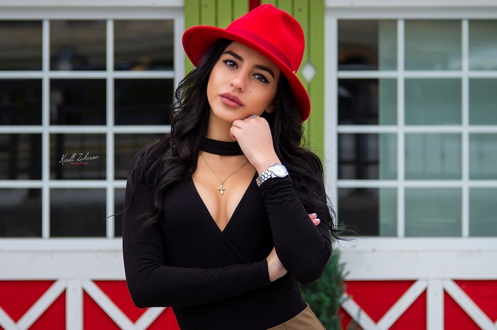 Woman wearing a red hat and black top outdoors