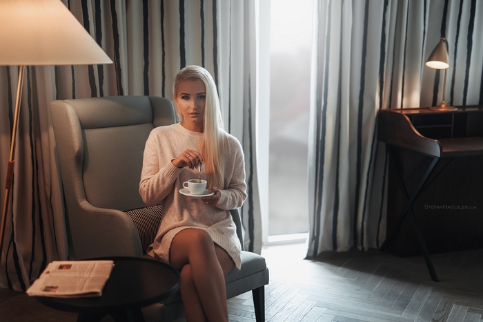 Woman in sweater dress holding coffee cup