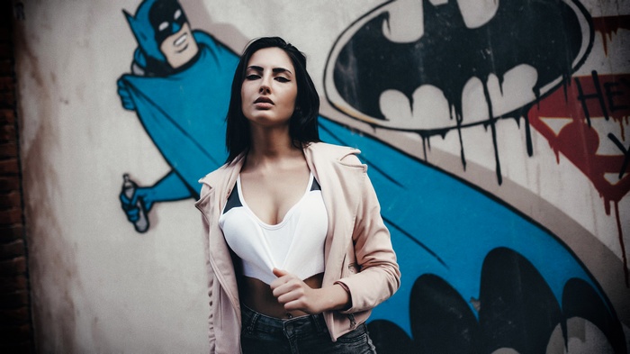 Woman in front of Batman graffiti