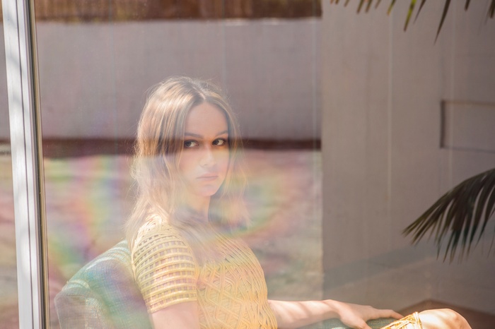 Brie Larson sitting by a window