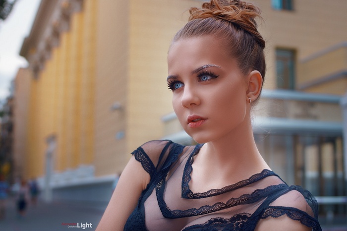 Woman with blue eyes and glittery eyebrows outdoors