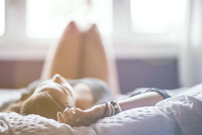 Woman lying on bed with sunlight
