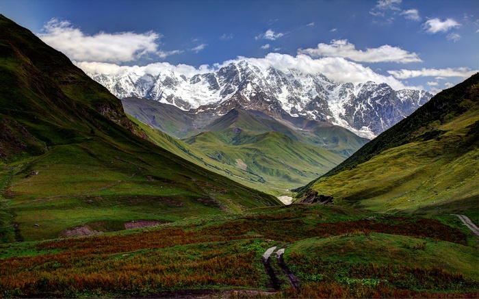 Snowy mountains and green valley in Georgia