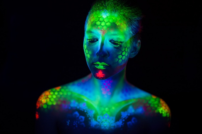 Woman with colorful body paint in dark