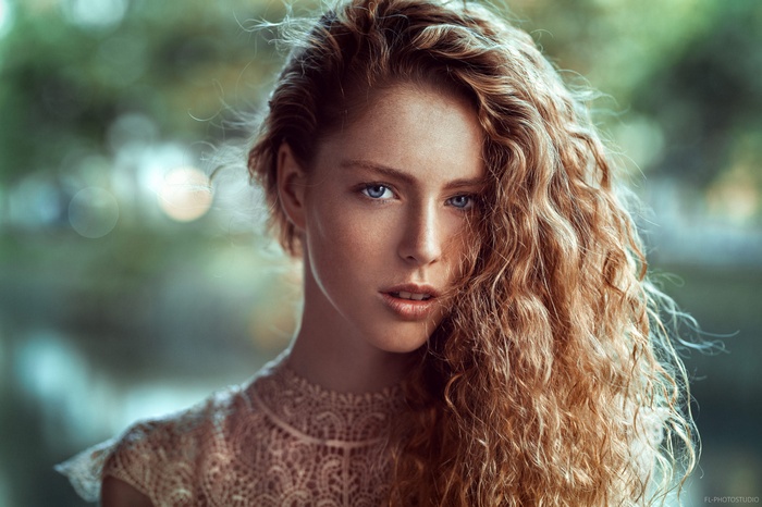 Woman with wavy red hair and blue eyes