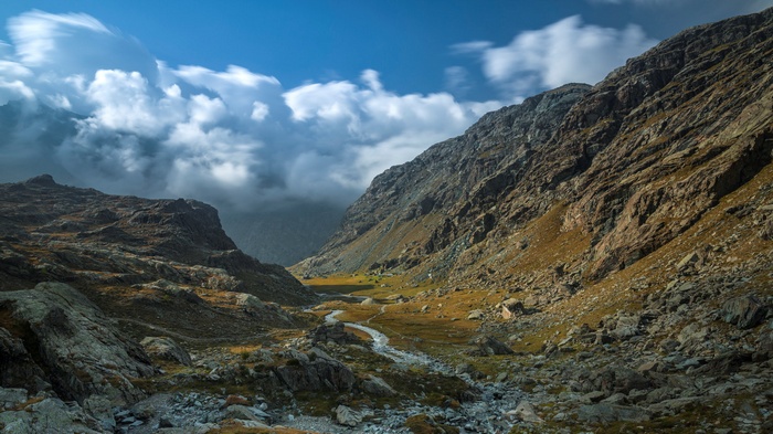 Mountain valley with a river and clouds