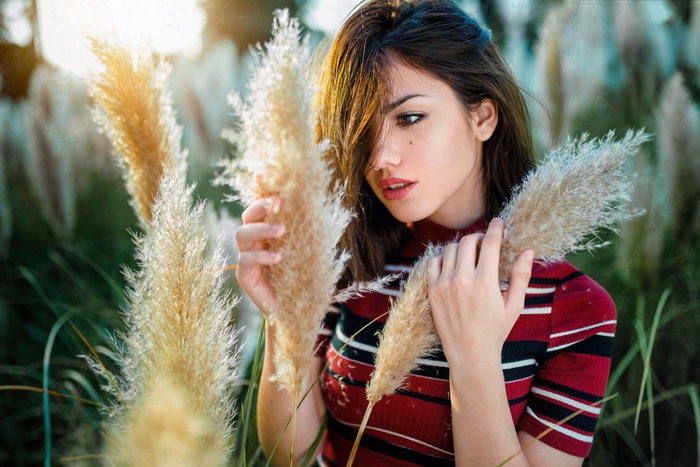 Woman in striped shirt holding tall grass