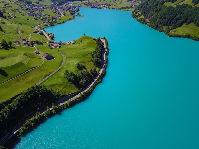 Aerial view of a turquoise lake and green landscape in Switzerland